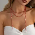 Nahaufnahme der Vintage roten Perlen- und Saatperlen-Y-Halskette an einem Modell für Damen - Rot und Weiß Stil (07786)
