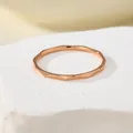 Macro detail of the rose gold water ripple titanium steel ring on a white stone base - US 5 / Rose Gold