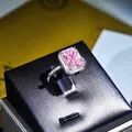 Detaillierte Nahaufnahme eines luxuriösen Rings mit rosa rechteckigem Edelstein und Halo - Prinzessin Radiant Schliff (010 Rosa) / Einstellbar Offen / Rosa Zirkonia Ring