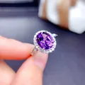 Close-up of an elegant oval purple amethyst ring with a halo of sparkling crystals - Adjustable Open / Silver Purple