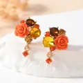 Close-up detail of floral stud earrings with orange resin roses and faceted warm-toned crystals - Rose Flower Teardrop Style (WEH4364) / Orange
