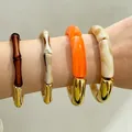 Stack of chunky acrylic bamboo-style and marbled bangles with gold-tone accents - Brown/Beige/Orange/Creamy 4-Piece Patchwork Bangle (32832)