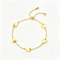 Vista detallada de la pulsera de corazones en acero inoxidable chapada en oro de 18k. - Estilo de 5 Corazones Sólidos / Dorado
