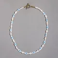 Close-up detail of evil eye motif beads and white pearls on a gold toggle necklace - Style M (Evil Eye Pearl Necklace) / One Size / 43cm / White