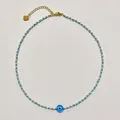 Close-up view of a handcrafted beaded evil eye necklace with light blue and gold accents - Style P / One Size / 38+5cm / Blue White Gold