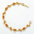Detailed view of an elegant gold-plated vine bracelet with faceted orange stones - Gold Orange Zirconia Tulip