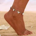 Elegant silver-toned anklet featuring detailed butterfly charms on a summer beach background - Butterfly Pendant / Silver