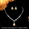 Close-up detail of golden teardrop zircon necklace and earrings set on black display - Teardrop Style (GS021) / Gold Yellow