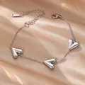 Pulsera sencilla de acero de titanio plateado con tres corazones sobre satén champán - Corazón Puntiagudo (E2019) / Color acero