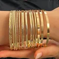 Detailed view of ten-piece gold-toned bangle set with various textures on wrist - 15 Pieces Collection (A-518)