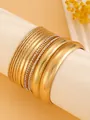 Detailed close-up of a 10-piece ethnic golden alloy bangle set featuring various textures. - Gold (A-515)