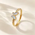 Detailopname van een gouden vlinderring met wit parelmoer en fonkelende zirkonia-stenen. - US 6 / Goud