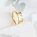 Close-up detail of a minimalist 18k gold ring with a sparkling square zirconia stone - US 7 / Gold