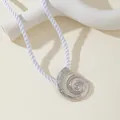Vue détaillée d'un pendentif conque argenté avec une cordelette tressée blanche - Collier Argenté