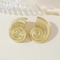 Vue macro de boucles d'oreilles nautile dorées aux textures de style bohème de plage - Boucles d'Oreilles en Or