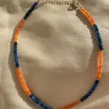 Dettaglio ravvicinato di perle di pietra naturale sfaccettate blu e arancioni su collana. - Stile contrasto blu e arancione (19)