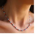 Dettaglio macro di una collana sottile con perle colorate e pietre naturali rosse e blu - Stile perline rosso e blu (26)