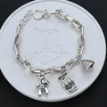 Vintage silver link chain bracelet featuring horse, dollar bill, and textured bell charms - Banknote & Horse Pendant Style (SL0241)