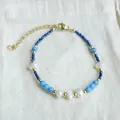 Detailed view of handmade beaded bracelet with blue stones, pearls, and gold accents. - Blue-Green Stackable Style with Heart Clasp (Bracelet 8) / 17+3cm