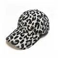 Close-up detail showing the plush leopard print texture and metal M logo on the cap. - Black