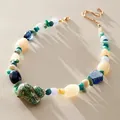 Detailweergave van handgemaakte kralenketting met een natuurlijke schelp hanger - Wulkhanger Ketting / 38+5cm / Gemengde groene ronde kraal