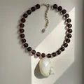 Elegante ketting met bruine kralen en een grote natuurlijke schelp hanger - Zwarte Kraal Stijl / 38+5cm / Zwart