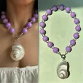 Handgemaakte paarse kralenketting met een grote hanger van een natuurlijke schelp voor dames - Wulkhanger Ketting / 38+5cm / Paarse ronde kraal