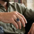Gros plan d'une bague vintage en acier titane pour homme avec pierre carrée noire - Agate noire acier