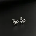 Close-up of minimalist stainless steel bow-shaped stud earrings with silver finish - Bow / 1 Piece / Steel