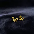 Detailed close-up of gold-plated stainless steel bow-knot stud earrings on velvet - Bow / 1 Piece / Gold