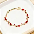 Elegant gold-tone bracelet featuring vintage red stones and a refined floral leaf design - Gold with Red