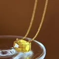 Close-up of yellow irregular cut crystal pendant on a minimalist gold chain. - Gold