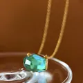 Close-up detail of a minimalist emerald green irregular cut crystal necklace. - Aquamarine