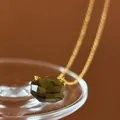 Close-up of minimalist gold necklace with irregular cut olive green crystal pendant - Olive Green