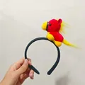 Detail view of cute red and yellow plush horse toy attached to a black headband - Little Pony