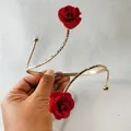 Detailaufnahme eines eleganten goldenen Armreifs mit zwei roten Stoffrosen. - 33521-ab-red-EP