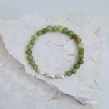 Vue détaillée de perles d'eau douce et de perles de pierre verte sur fond de pierre brute - Style perle en pierre naturelle verte (Bracelet 4)