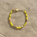 Détail d'un bracelet avec des perles en cristal jaune et une perle d'eau douce naturelle - Cristal jaune éclatant avec accents violets et oranges (Bracelet 9)
