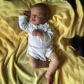 Lifelike 19-inch reborn baby doll Loulou sleeping peacefully in a white onesie on a yellow blanket - White Long-Sleeve Romper / Full Vinyl Body