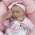 Realistic 19-inch sleeping reborn baby doll Loulou with pink bow headband and outfit - Pink and White Romper / Full Vinyl Body