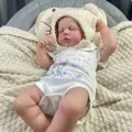 Lifelike 19 inch reborn baby doll Loulou wearing a white onesie and fuzzy knit hat - Hat and Romper Set / Full Vinyl Body