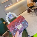 Detail view of mini PVC jelly bag featuring pearl handle and pink gradient color. - Transparent Pink