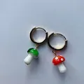 Vue détaillée de boucles d'oreilles créoles avec breloques champignons en verre rouge et vert - Taille unique / Boucles d'oreilles créoles champignons en verre de lampe rouge et vert