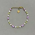 Détail d'un bracelet en pierres naturelles colorées avec un pendentif en cœur doré - Style de perles facettées violettes et vertes et perles olive blanches / Taille unique / 17+3cm / Violet et Vert