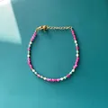 Vue détaillée d'un bracelet en pierre naturelle colorée avec fermoir mousqueton réglable - Modèle de perles facettées rouge rose blanc bleu et perles de séparation dorées / Taille unique / 17+3cm / Bonbons Multicolores