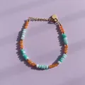 Vue détaillée d'un bracelet en pierres naturelles colorées avec un pendentif en cœur - Style de perles facettées orange et bleues disposées en alternance / Taille unique / 17+3cm / Bicolore Orange Bleu