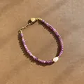 Détail d'un bracelet en perles d'améthyste violette avec une perle baroque blanche au centre - Style de perles rondes violettes et pierre blanche irrégulière unique / Taille unique / 17+3cm / Violet