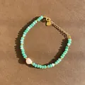 Détail d'un bracelet en pierre naturelle verte avec une perle rose sous un soleil éclatant. - Style de perles facettées vert clair et pierre irrégulière rose / Taille unique / 17+3cm / Vert clair