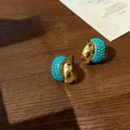 Elegant gold-plated hoop earrings with vibrant turquoise bead accents. - Curved Blue Turquoise Hoop Style (E1122) / Gold
