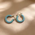 Elegante zilveren oorringen met blauwe turquoise stenen op een zachte beige stof - Grote Cirkel Turkoois Stijl (E3062) / Zilver